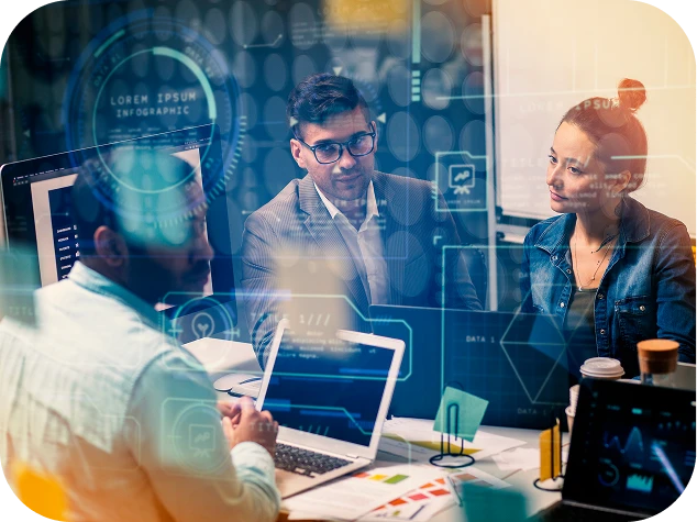 equipo de trabajo de tres personas sentadas en una mesa con sus computadores portátiles para una reunión de trabajo